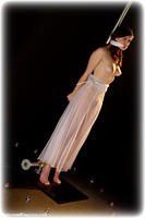 Free bondage photo Fawna Latrisch rope bondage, barefoot, gown, bondage pole, cloth gag, topless, ungagged